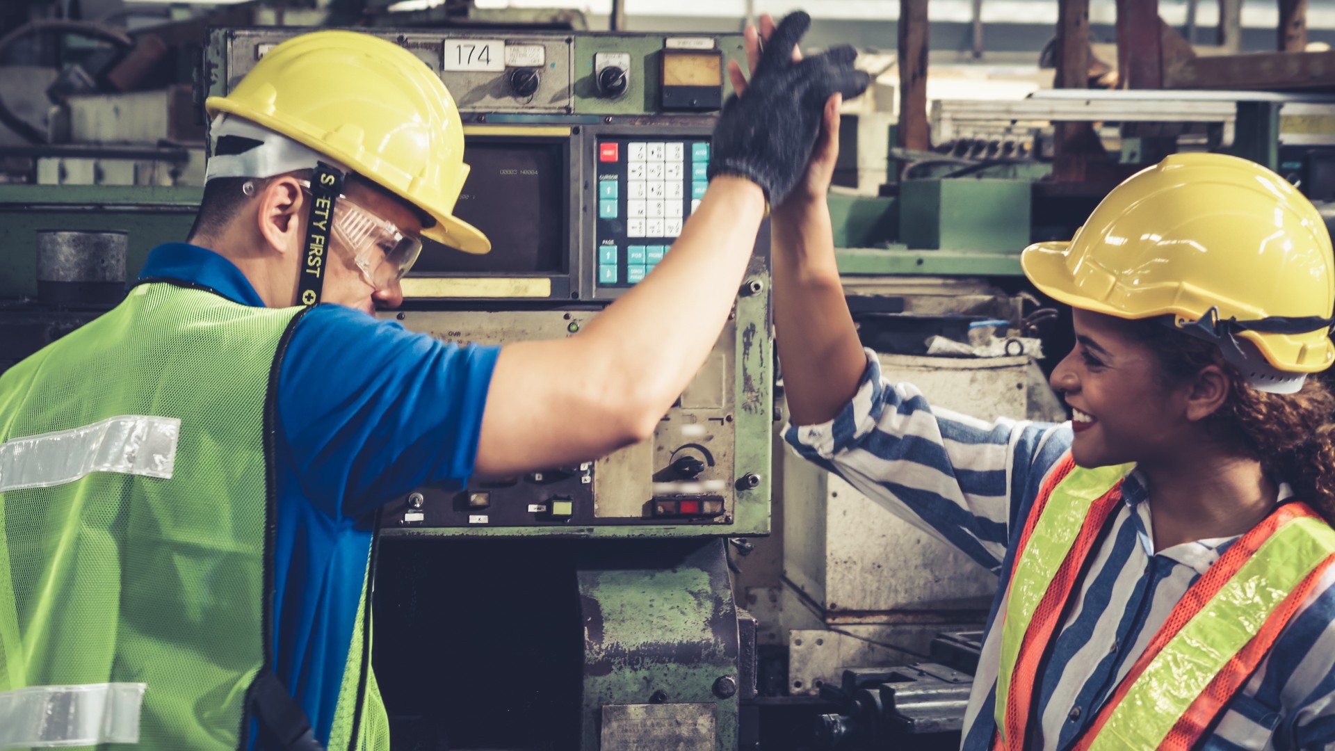 Group of factory workers using machine equipment in factory workshop